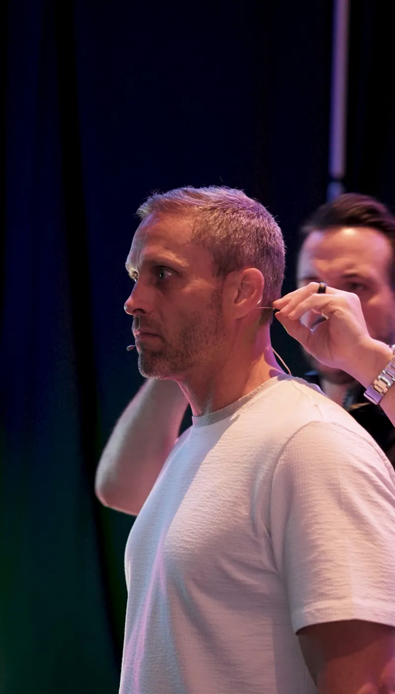 Matt Uhler Preparing for a Keynote Business Presentation Man being fitted with a microphone before speaking at a business event
